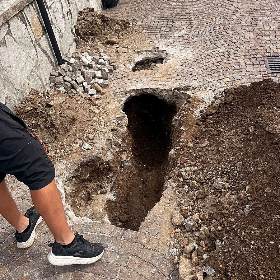 Strada aperta sul punto esatto di una perdita occulta, in un condominio
